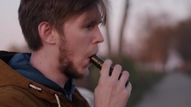 Портрет молодого человека на дороге Курение электронных сигарет — стоковое видео