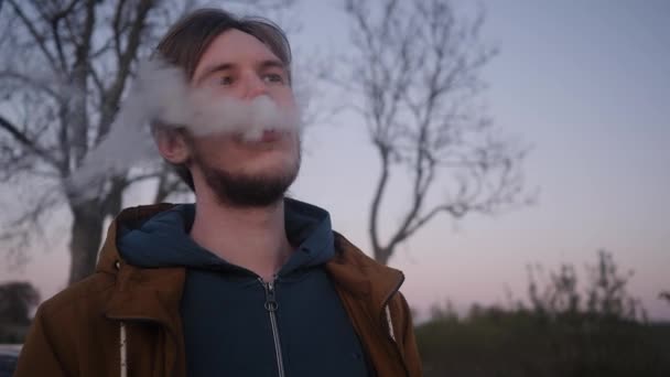 若い男と電子タバコの蒸気の距離に目を通す — ストック動画