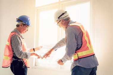 Kıdemli mühendis yönetim ekibi, proje zamanlamasını planya portresi.