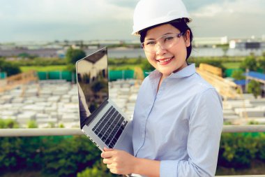 Mühendis kadın portresi fabrikada dizüstü muayene prekast beton ürün kullanıyor.
