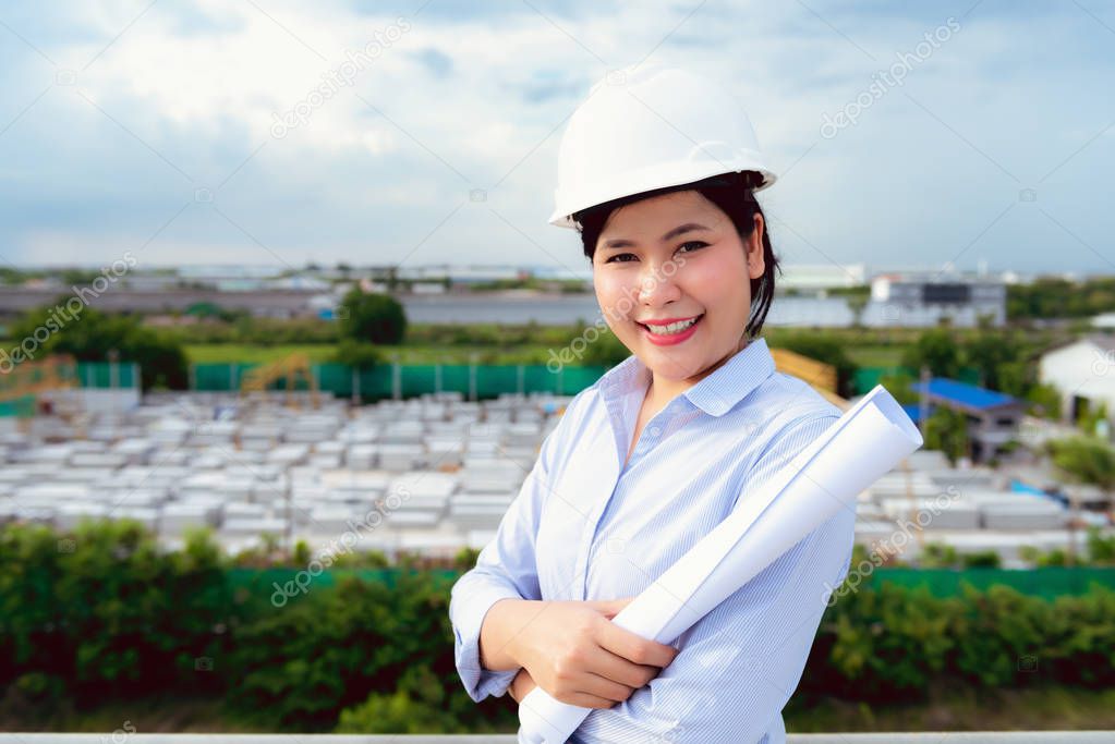 Portrait of engineer woman is holding paperwork for inspection precast concrete product in factory.