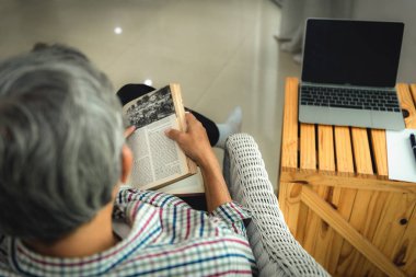 Komuta sizde ev., boş zaman aktiviteleri ve insanlar kavramı kanepe ve okuma kitabı üzerinde oturan.