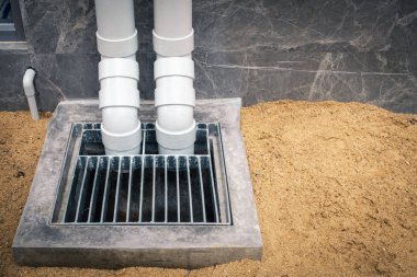PVC boru hattı çatı drenaj downspout ve beton kuyu inşaat sahasında.