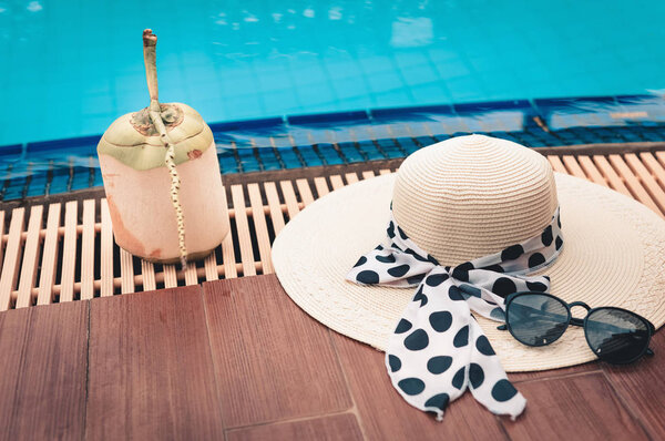 Соломенная шляпа и цветок plumeria на террасе бассейна
.