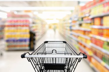 Mağaza ile tüketim malları ürün içinde arabası üzerinde raf arka plan. alışveriş, soyut hareket kavramı bulanık.