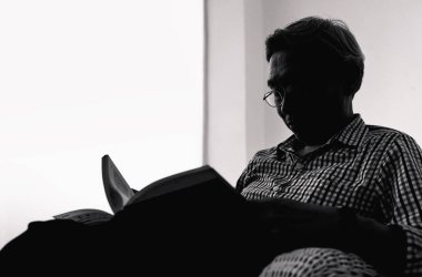 Komuta sizde salon., siyah ve beyaz bir kitap okuyor