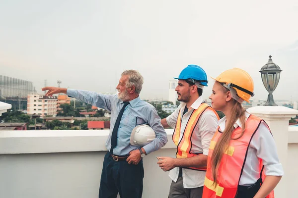 Project management team of engineer and architect discussing action plan their project and site visit inspection., Business construction concept.