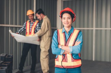 Mühendis kadın portresi diğer teknisyen adamların önünde duruyor.