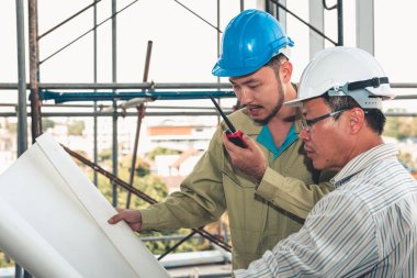 İnşaat Mühendisi yüklenici komut mobil radyo aracılığıyla konuşuyor. 