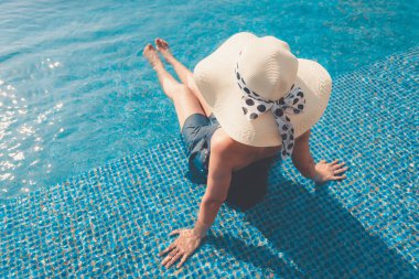 Asyalı kadın ile sunbathe yüzme havuzunda rahatlatıcı portresi.