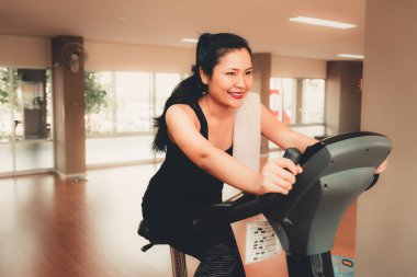 Spor salonunda Bisiklete binme çekici genç kadın portresi kapatın.
