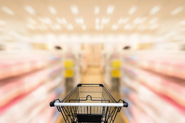 Shopping trolley in department store with consumer goods product on shelf background., Abstract motion blurred concept.