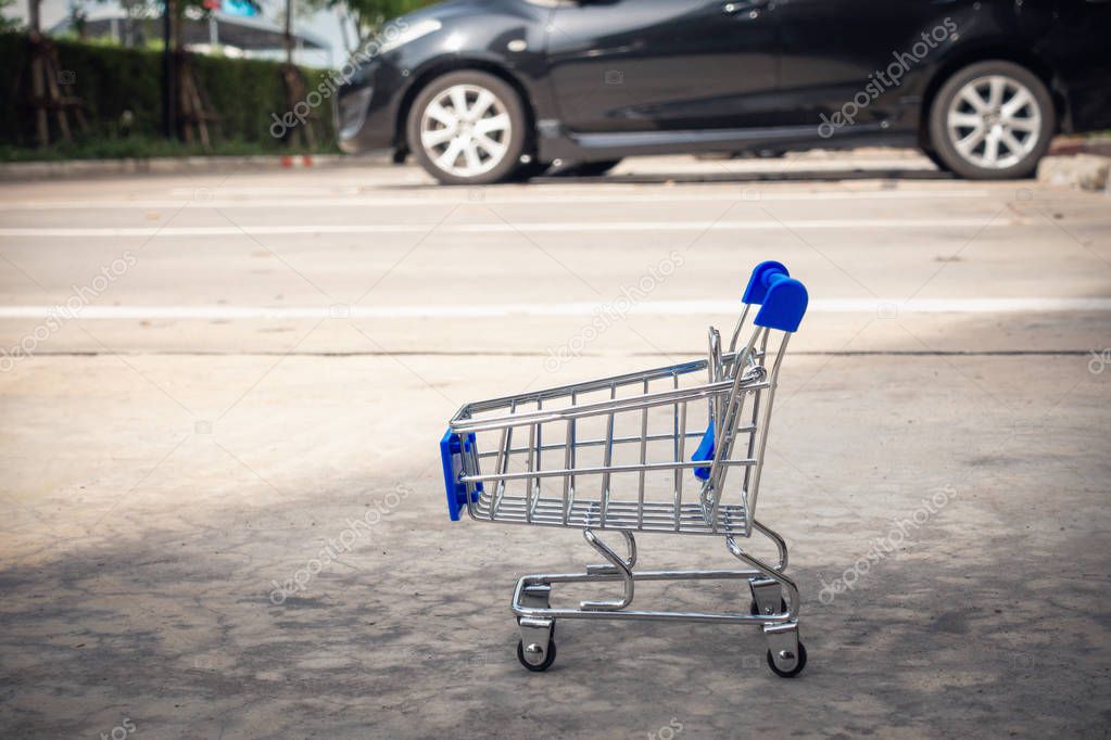 Mini shopping cart in car parking lot., Shopping concept.