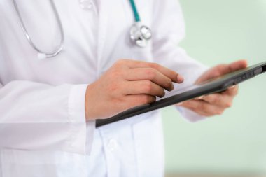 Kadın tıp doktoru closeup tablet fiziksel hasta muayene için kullanma.