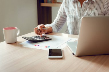İşkadını muhasebeci ofis oda. içinde iş mali, vergi, muhasebe kavramı tasarruf finansal verileri eşleştirmek için hesap makinesi ve dizüstü kullanarak portresi kapatın.