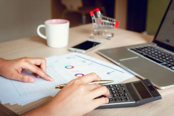 Close up portrait of businesswoman accountant using calculator and laptop for matching financial data saving in office room., Business financial, tax, accounting concept.