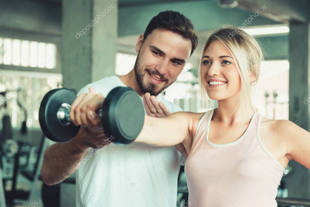 Beautiful sexy woman in fitness gym training with fitness equipment in sport gym and many bodybuilding, Lifting weight loss ,Portrait couple people exercise body gym Sporty and healthcare concept.