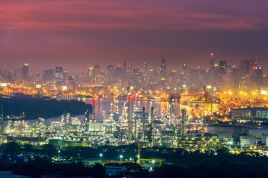 Petrol gaz rafineri imalat sanayi tesisi alacakaranlık sahne içinde Bangkok şehir, Tayland., iş fabrika Petrokimya enerji güç veya endüstriyel ve ağır inşaat cityscape içinde kara.