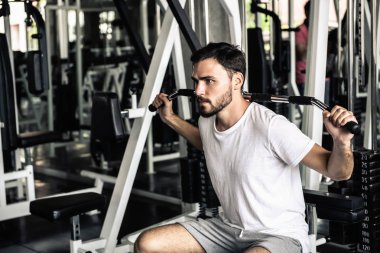 Yakışıklı adam egzersiz fitness club., spor, sağlıklı ve fitness spor spor salonu konsept yakıcı kalori dışarı çalışma yapan güçlü erkek portresi vücut geliştirmeci makine ile kürek.