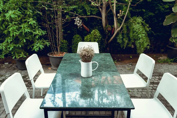 Home and outdoor gardening decoration with bouquet in a vase layout on granite table desk., House or restaurant shop of resting area design.