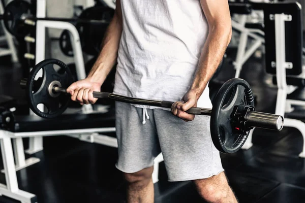 Schöner Mann rudert mit Bodybuilder-Ausrüstung im Fitnessstudio — Stockfoto