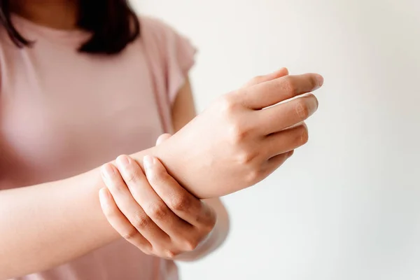 Nahaufnahme der Frauenhand massiert ihre Handgelenkschmerzen bei den Hausaufgaben — Stockfoto