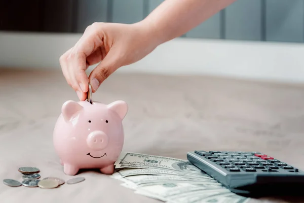 Close-Up Woman Hand está colocando uma moeda em Piggy Bank — Fotografia de Stock