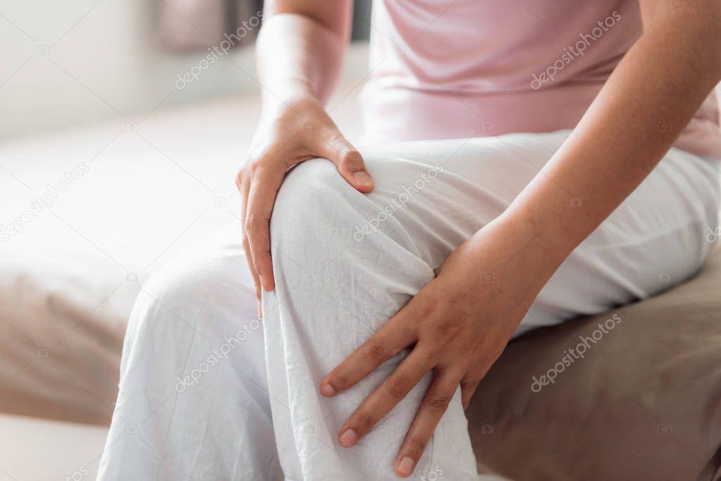Close-Up of Woman Hands is Massaging Her Knee on a Bedroom