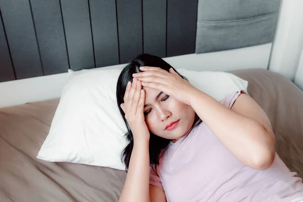 Porträtt av ung kvinna med Depression lider med huvudvärk från sömnlöshet på hennes sovrum., sjukvård och medicin koncept. — Stockfoto