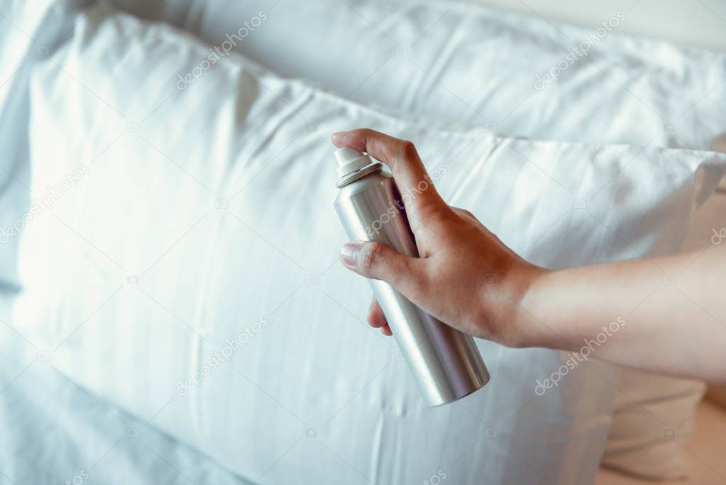 Woman Hand is Spraying Air Freshener into Pillow on Bedroom, Unpleasant Smell and Aromatherapy Concept.