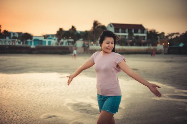 Güzel kadın portresi zevk ve tatil zamanında sahilde rahatlatıcı, gün batımı sırasında kum plajında seyahat tatil Asya kız mutluluk duygu. Boş zaman etkinlikleri ve yaşam tarzı.