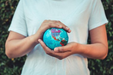 Earth ve bakım çevre kavramı, yakın çekim kadın portre Holding Mockup ağaç arka planda bırakmak onun elinde geneldir. Gezegen ve kavramsal seyahat kaydetmek.