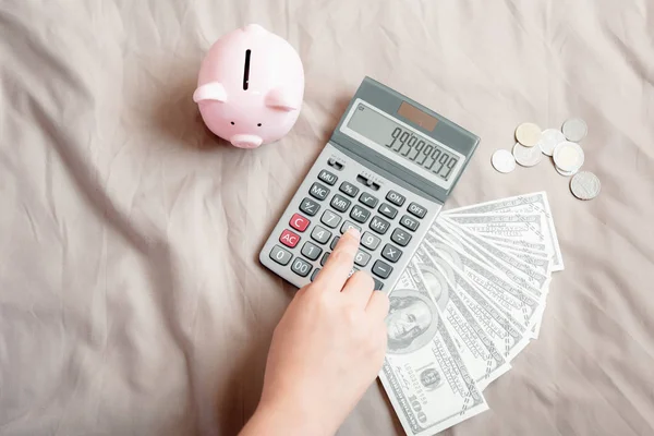 Primer plano de la mano de la mujer está utilizando la calculadora para calcular el ahorro de dinero de contabilidad o reclamo de gastos en su dormitorio, la banca empresarial y el concepto financiero . — Foto de Stock