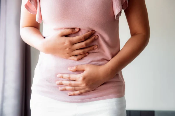 Kvinnan är att ha ont i magen eller menstruation är närbild porträtt av ung kvinna lidande från buksmärtor på hennes hem. Vård och medicin koncept. — Stockfoto