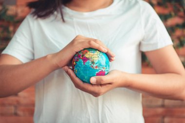 Earth ve bakım çevre kavramı, yakın çekim kadın portre Holding Mockup ağaç arka planda bırakmak onun elinde geneldir. Gezegen ve kavramsal seyahat kaydetmek.