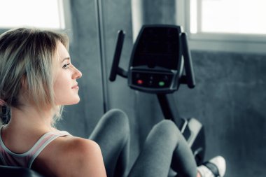 Spor salonunda bisiklet egzersizi, Spor yaparken gülümseyen güzel kız, spor salonunda bisiklet eğitimi alan güzel beyaz kadın portresi..