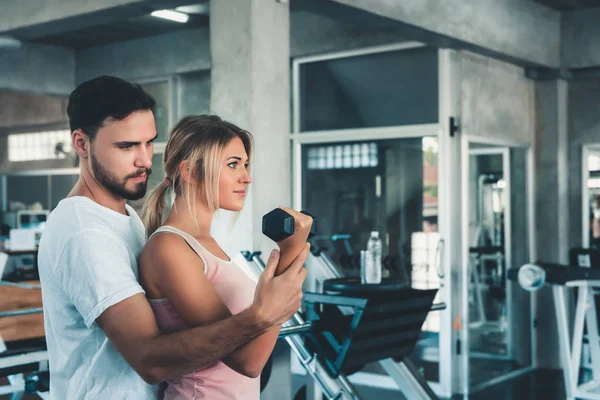 Retrato del amor de pareja en el entrenamiento de fitness con equipo de mancuerna., Pareja joven caucásica están haciendo ejercicio y entrenando juntos en el gimnasio Club., Deporte y concepto saludable . — Foto de Stock