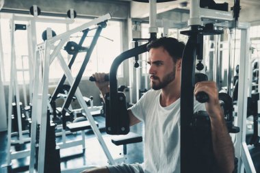 Yakışıklı adam egzersiz ile göğüs Fitness Club., portre, güçlü adam yapıyor çalışma dışarı kalori yakma spor salonunda, sağlıklı ve Fitness yaşam tarzı kavramı makinesidir.
