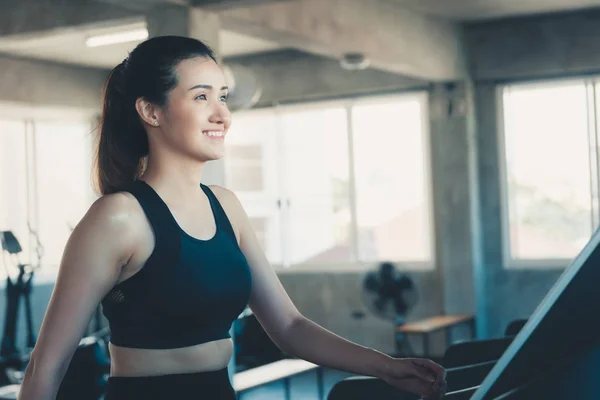 Primer plano de mujer deportivo es hacer ejercicio en el gimnasio, mujer atractiva es ejercido para correr en caminadora gimnasio, Club de deporte y sano concepto. — Foto de Stock