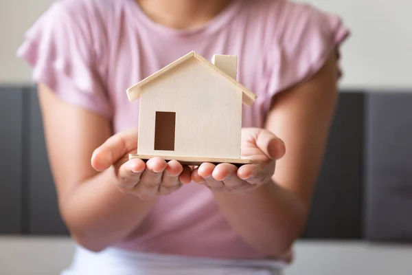 Close-Up of Woman Hands está segurando o modelo de habitação para economia de dinheiro em seu quarto, negócio bancário ou imobiliário e conceito financeiro . — Fotografia de Stock