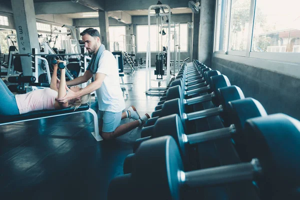 Retrato del amor de pareja en el entrenamiento de fitness con equipo de mancuerna., Pareja joven caucásica están haciendo ejercicio y entrenando juntos en el gimnasio Club., Deporte y concepto saludable . — Foto de Stock