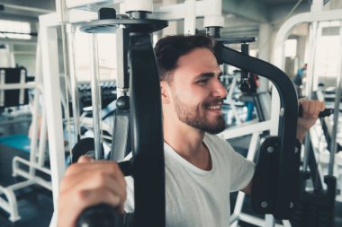 Yakışıklı adam egzersiz ile göğüs Fitness Club., portre, güçlü adam yapıyor çalışma dışarı kalori yakma spor salonunda, sağlıklı ve Fitness yaşam tarzı kavramı makinesidir.