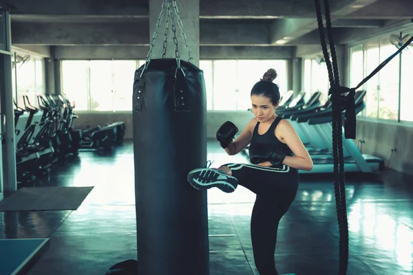 Boxeadora femenina está entrenando puñetazos en el club de fitness., Retrato de boxeo Mujer está practicando juego de pies con bolsa de boxeo., Hermosa de chica asiática haciendo ejercicio en el gimnasio . — Foto de Stock