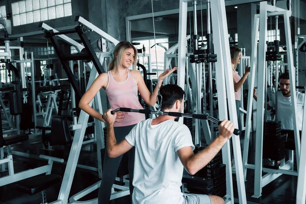 Retrato de amor de casal no treinamento de fitness com equipamentos de musculação., Casal jovem caucasiano estão trabalhando e treinando juntos no clube de ginástica., Esporte e conceito saudável . — Fotografia de Stock