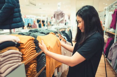 Tüketicilik ve Güzellik Moda Mağazası Concept.Portrait pretty woman yeni giysiler arıyor ve Alışveriş Mağazası seçimi., Shopaholic Lifestyles ve Eğlence Etkinlikleri.