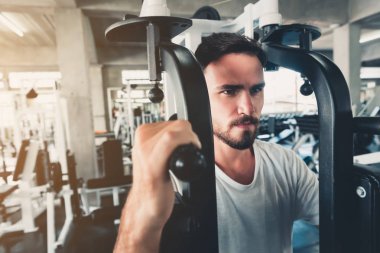 Yakışıklı adam Fitness Club bodybuilder makine Ile egzersiz, güçlü adam portre spor salonunda kalori yakma çalışma yapıyor., sağlıklı ve fitness Lifestyle Concept.