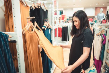 Tüketim ve güzellik moda Atölyesi kavramı, güzel kadın portresi yeni giysiler arıyor ve Alışveriş Mağazası seçimi, alışverişkolik yaşam ve eğlence faaliyetleri.
