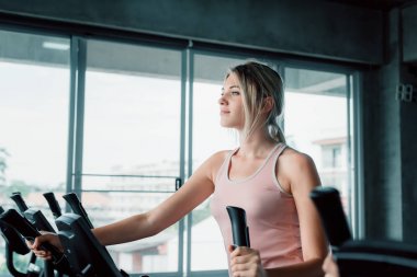 Sportif kadın fitness eliptik egzersiz portresi., jimnastik salonu, Wellness Programı ve spor sağlıklı konsept eğitim dışarı spor beyaz kadın güzel.