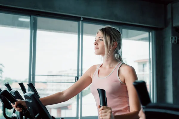 Retrato de una mujer deportiva haciendo ejercicio elíptico en forma física., Pretty of Caucasian Women in Sportswear ejercitando el entrenamiento cardiovascular en el gimnasio., Programa de bienestar y concepto saludable del deporte . — Foto de Stock