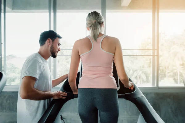 Beautiful Woman es Entrenamiento de Ejercicio con Máquina de Cinta de Correr en Fitness Club., Atractivo de Chica Deportiva Haciendo Ejercicio con Su Entrenador en Gimnasio, Saludable y Deportivo Ejercitando Concepto de Estilo de Vida . — Foto de Stock